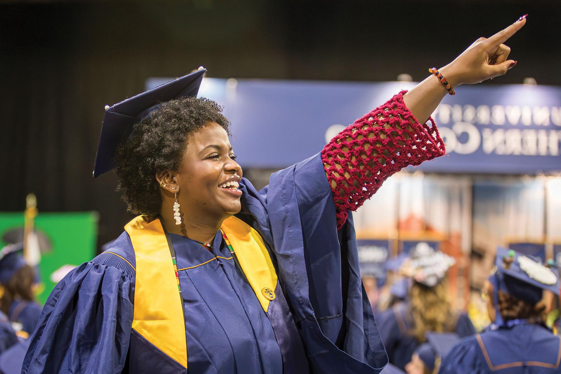 An undergraduate student points out into the crowd at the Spring 2024 UNC Commencement Ceremony.